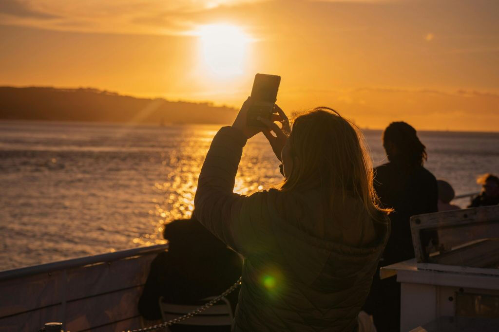 Cruzeiro ao pôr do sol no rio Tejo em Lisboa com bebidas e petiscos